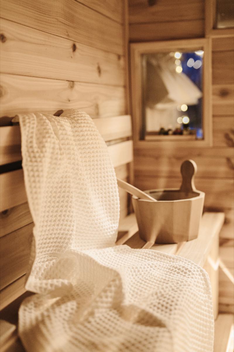 RO Sauna fired up at dusk — warm glow from the barrel